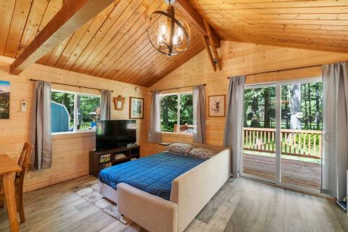 阿什福德Cozy Cedar Cabin Steps Away From Mt. Rainier的一间卧室配有一张床和一台平面电视