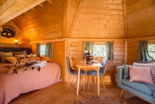 Le Kota B&B 4****的小木屋卧室配有两张床和一张桌子