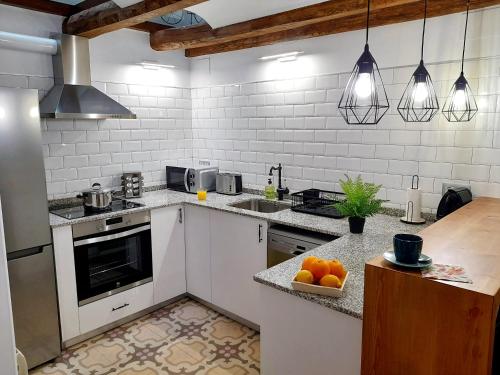 VimbodíCal Passió的厨房配有白色家电和橙色的柜台