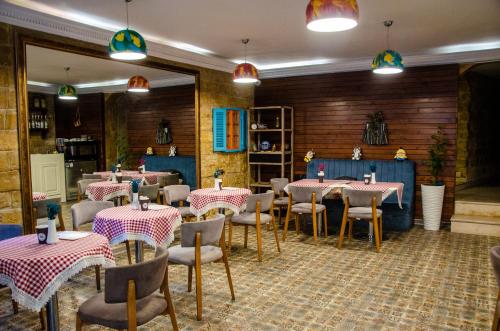 巴库Qala Hotel的一间在房间内配有桌椅的餐厅