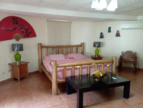 里奥阿托Sunrise Hostel Farallon的一间卧室配有一张带粉色床单和一张桌子的床。
