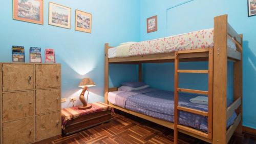利马贝拉加家庭旅馆的一间卧室配有两张双层床和一盏灯。