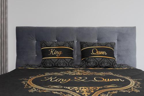 托伦Szampan i Truskawka的一张带黑色和金色床单和枕头的床