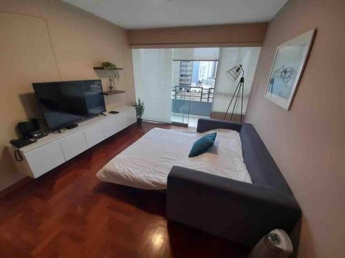 利马MLA apartments - Kennedy的客厅配有床和平面电视