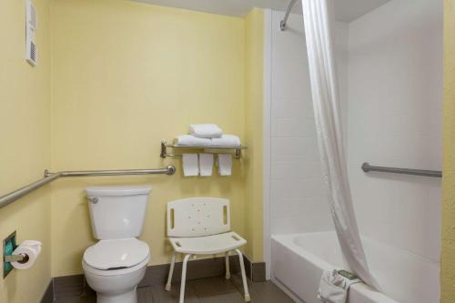 路易斯威尔Best Western Louisville East Inn & Suites的一间带卫生间、浴缸和椅子的浴室
