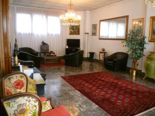波代诺内米内尔瓦酒店的客厅配有家具和吊灯。