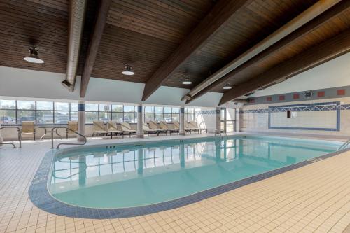 德赖登德赖登贝斯特韦斯特PLUS酒店会议中心的大型客房的大型游泳池,配有桌椅