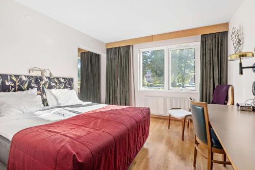 阿斯克松德贝斯特韦斯特诺拉韦特恩酒店的一间卧室配有一张床铺和一张桌子,还有一间用餐室
