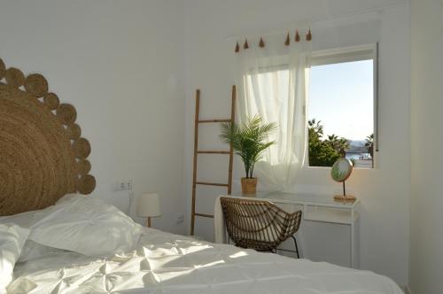 阿罗纳Rosamar 211 Los Cristianos Ocean Views的一间卧室配有一张床、一张书桌和一个窗户。