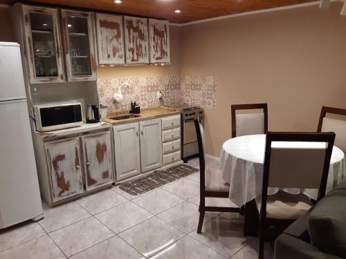 格拉玛多Rifugio del Camino - Chalé Completo的厨房配有桌子和白色冰箱。