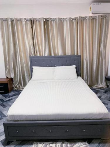 特马Lovely 1-bedroom rental unit for short stays.的床上床,床架和窗帘