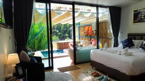 素叻Phetrapoolvilla (เภตราพูลวิลล่า)的一间卧室配有一张床,享有游泳池的景色