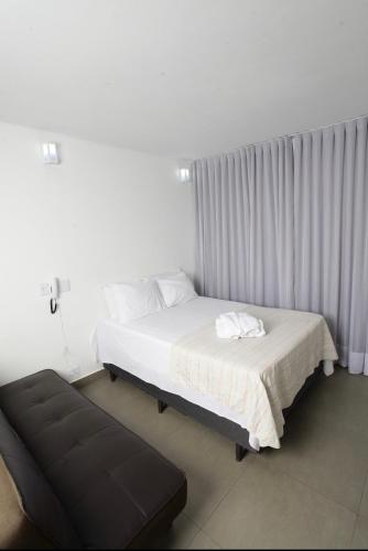 戈亚尼亚Apartamento 1009的一间卧室配有一张床和一张沙发