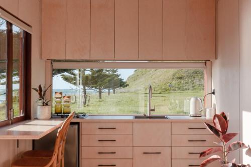 吉斯伯恩Tatapouri Bay的一个带水槽和大窗户的厨房