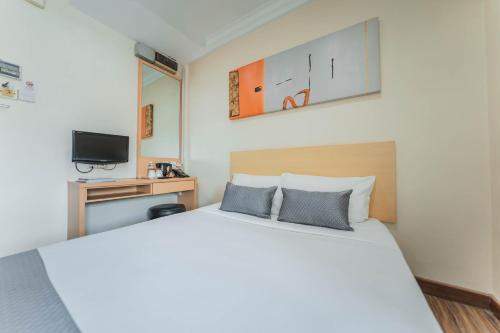 新加坡Hotel 81 Joy的卧室配有一张白色大床和电视。