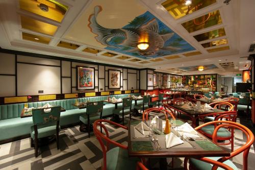 河内HOTEL du LAC Hanoi的餐厅设有桌椅,天花板上涂有鱼