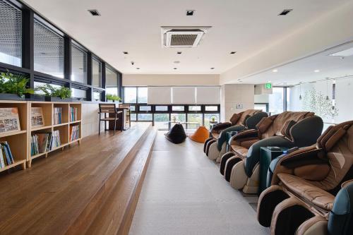 西归浦市蓝岛酒店的大型客房设有沙发和书架。