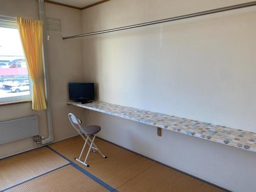 北斗oyado nanahoshi - Vacation STAY 59285v的一间带桌子和椅子的墙壁的房间