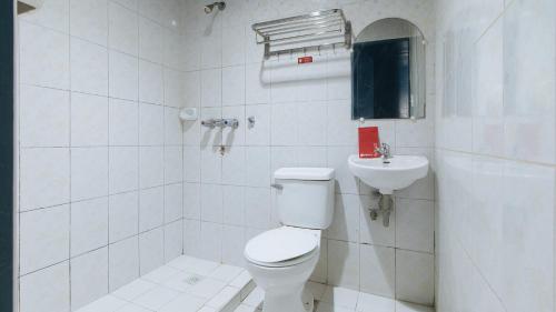 马尼拉RedDoorz @ Riches Holiday Hotel Avenida的白色的浴室设有卫生间和水槽。