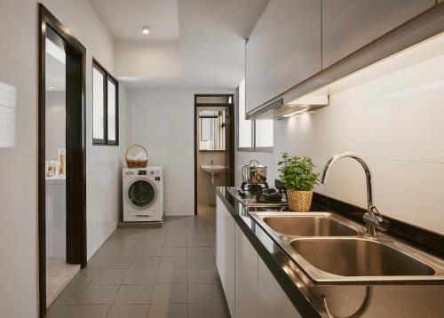 吉隆坡TRILLION SUITES by SLG的厨房配有水槽和洗衣机