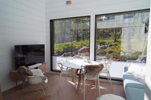 列维Levillas Utsunkulma 10B的客厅配有桌椅和电视。