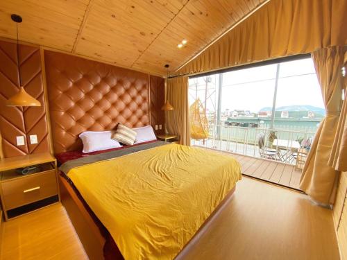 大叻Ngọc Nguyên Homestay的一间卧室设有一张黄色的床和一个阳台