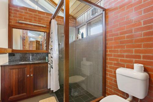 阿波罗湾阿波罗全景旅馆的一间带卫生间和玻璃淋浴间的浴室