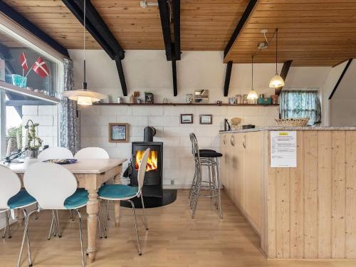 博恩瑟6 person holiday home in Bogense的厨房以及带桌子和壁炉的用餐室。