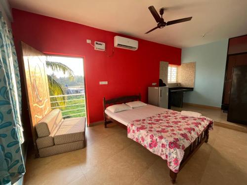 莫尔吉姆Morjim Guest House的一间卧室设有一张床和红色的墙壁