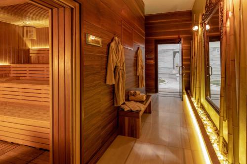 伯萨Hotel Çelik Palas Convention Center & Thermal SPA的一间带木墙和步入式淋浴间的桑拿浴室