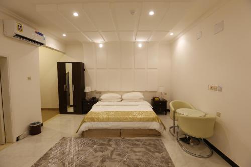 Taymāʼفندق حصن الأبلق - Alablaq Hotel的一间卧室配有一张床、一个水槽和一把椅子