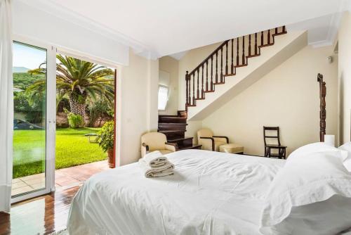 拉克鲁斯Villa Artigar, garden, swimming pool and bbq.的白色的卧室设有一张大床和一个楼梯