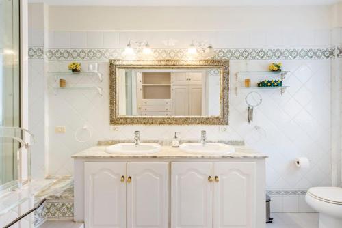 拉克鲁斯Villa Artigar, garden, swimming pool and bbq.的白色的浴室设有两个盥洗盆和镜子