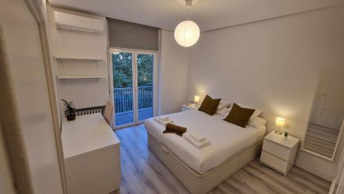 马德里Espectacular apartamento en Cuzco / Alberto Alcocer的卧室配有白色的床和窗户。