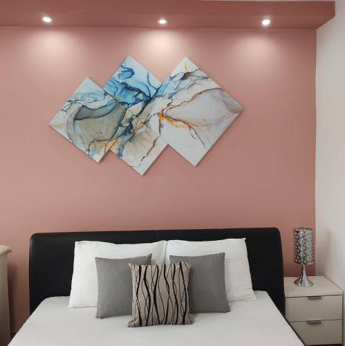 松博尔Apartman Maja的卧室配有一张墙上三幅画作的床