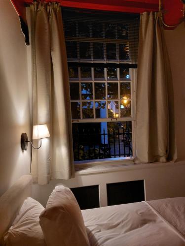 莱顿Het Waterhof的一间卧室设有一张床和一个美景窗户。