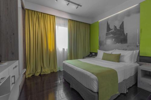 利雅德Super 8 Hotel Al Riyadh by Wyndham的一间卧室设有一张带绿色和黄色墙壁的床。
