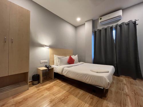 古瓦哈提Hotel Zen Garden的一间小卧室,配有一张床和电视