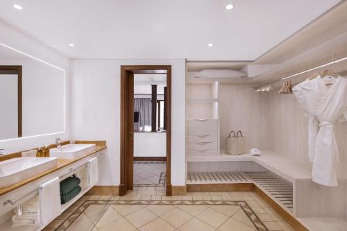 勒莫尔尼Paradis Beachcomber Golf Resort & Spa的浴室配有2个盥洗盆和1个浴缸。