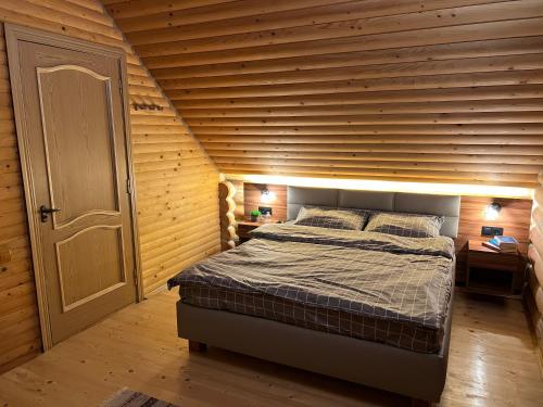 斯基希德尼萨Cottage Forest House的一间卧室配有一张木墙床