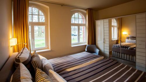 利兴Parkresidenz Lychen, Ferienwohnung 1的一间卧室设有一张床和两个窗户。