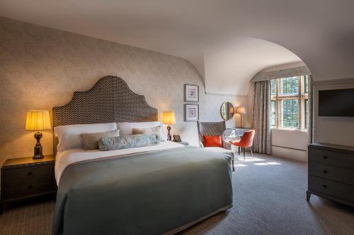 米尔顿凯恩斯Horwood House Hotel的一间卧室配有一张大床和电视