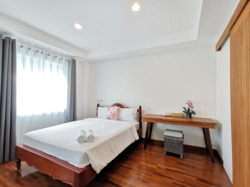 曼谷Sri Ayuttaya Guesthouse的一间卧室配有一张床、一张书桌和一个窗户。