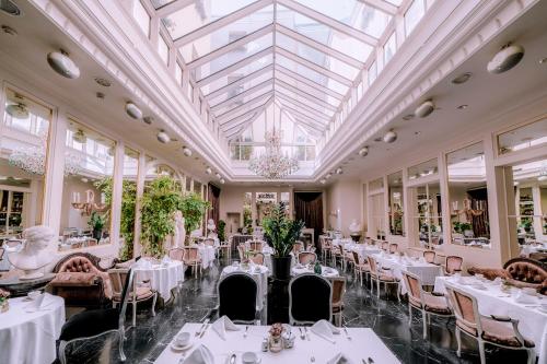 里加嘉逸豪庭酒店 - 立鼎世酒店集团的一间设有白色桌椅和玻璃天花板的用餐室