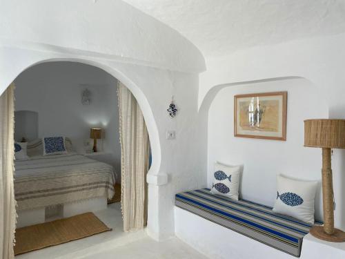 DjerbaDar Elbidha的白色卧室配有床和桌子