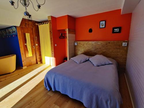 凯拉地区莫利讷Chalet Ailleurs Appartement à Molines en Queyras的一间卧室拥有橙色的墙壁,配有一张带两个枕头的床