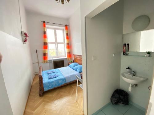 华沙Oliwka Hostel的小房间设有床和水槽