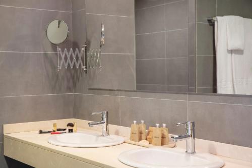克里斯托港Porto Drach Aparthotel & Suites的浴室设有2个水槽和镜子