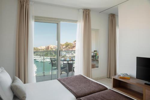 克里斯托港Porto Drach Aparthotel & Suites的酒店客房设有一张床,享有阳台的景色