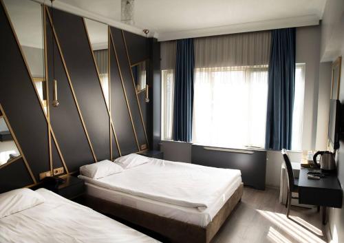 伊斯坦布尔Park Çağlayan Hotel的一间卧室设有两张床、一张桌子和一个窗口。